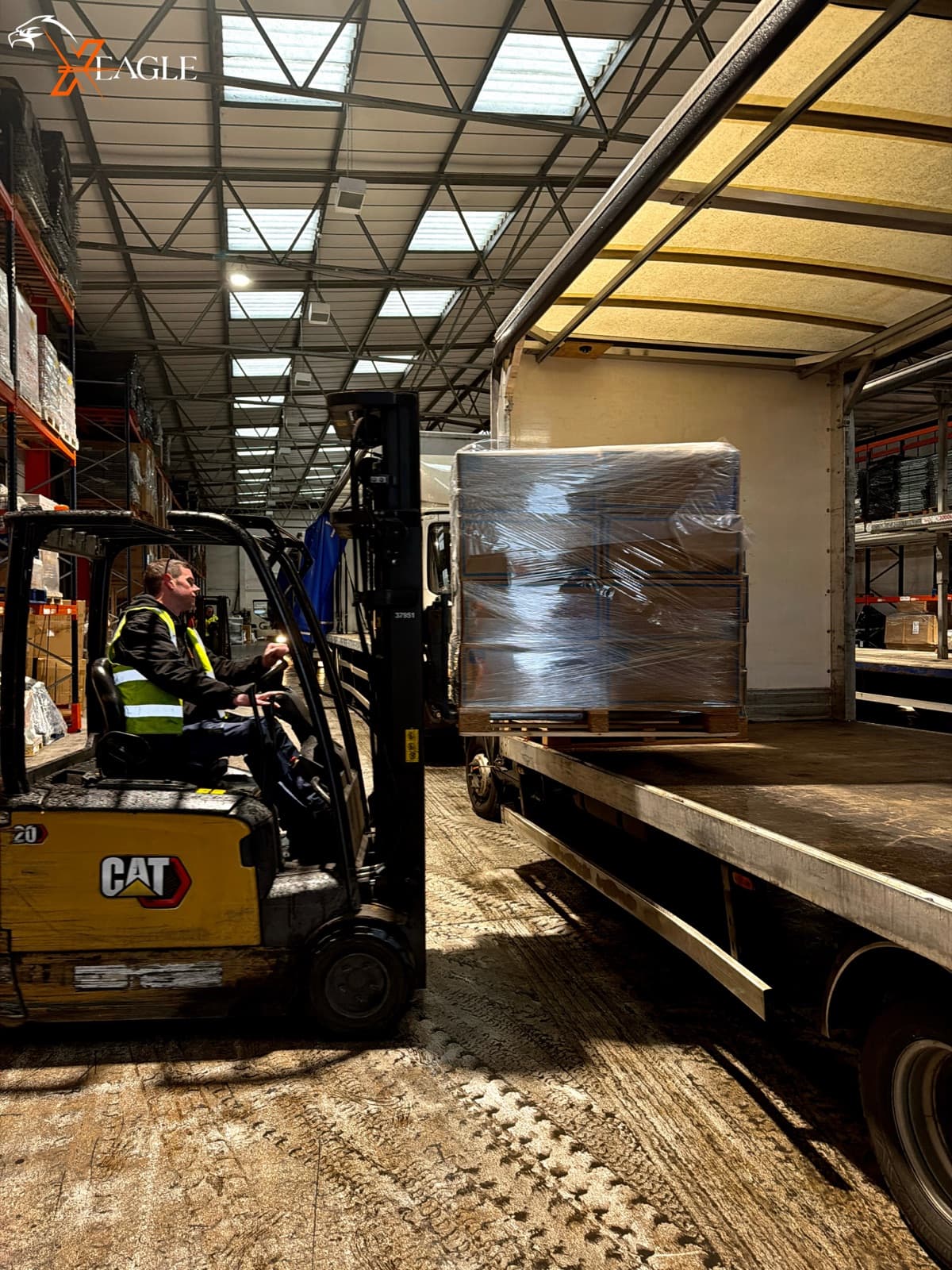 X-Eagle CAT forklift loading wrapped pallet onto curtain sider